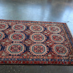 Persian-style runner rug corner view with red border and blue geometric lattice