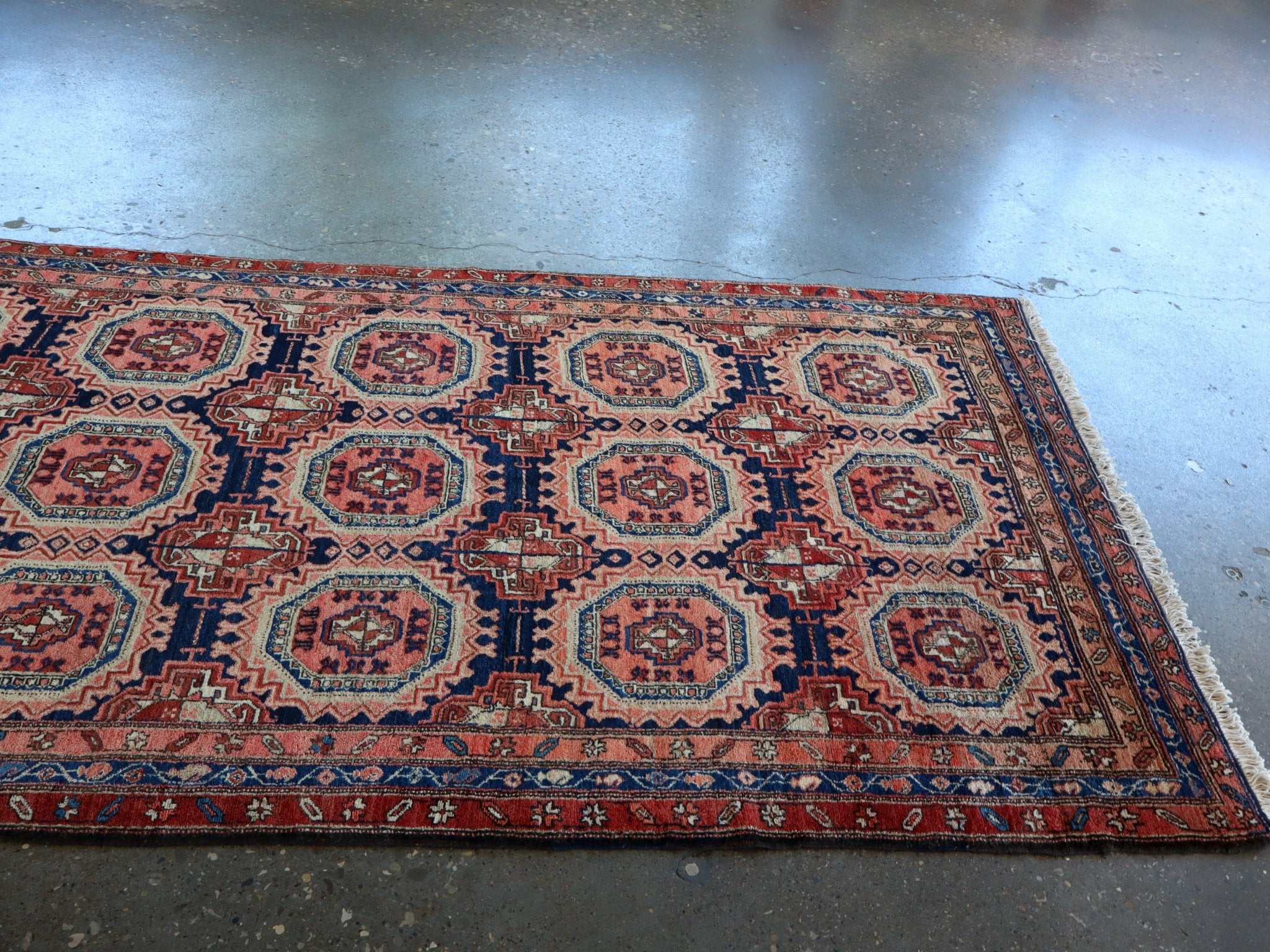 Persian-style runner rug corner view with red border and blue geometric lattice