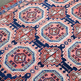 Persian-style runner rug close-up with red, blue, and cream diamond and octagon motifs