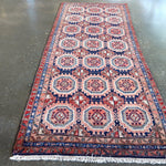 Persian-style meshkin runner rug with repeating octagon motifs in red, blue, cream