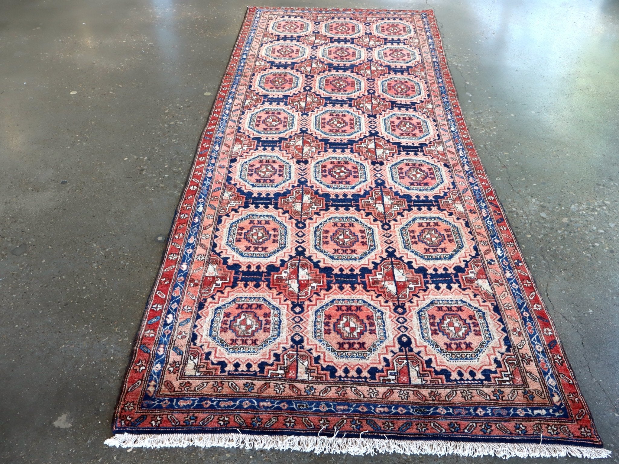 Persian-style meshkin runner rug with repeating octagon motifs in red, blue, cream