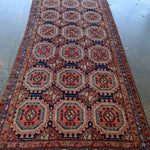 Persian-style runner rug with symmetrical red, blue, and cream octagon pattern