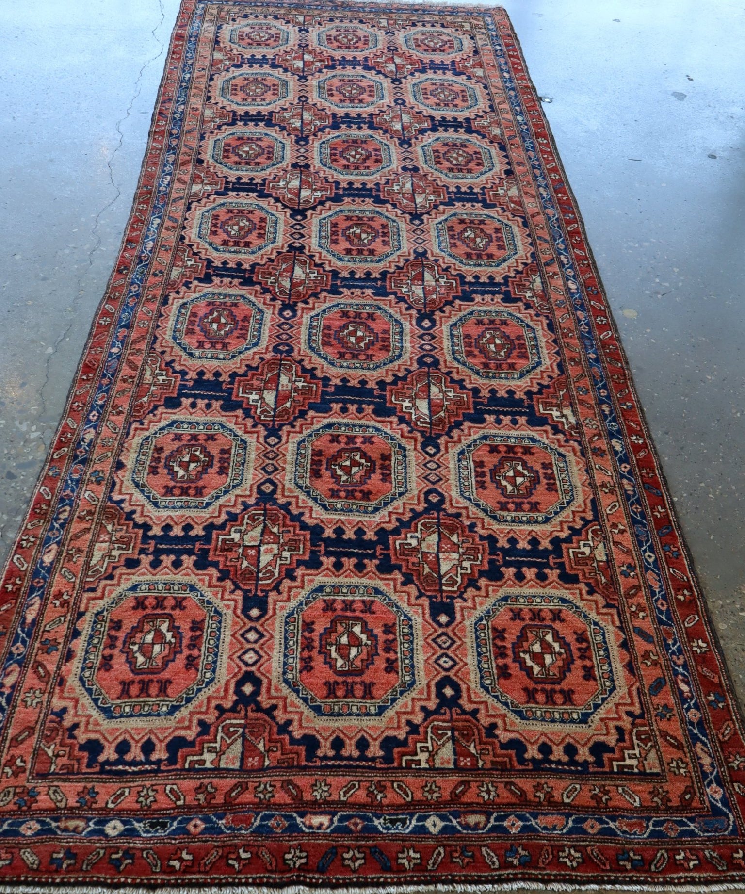 Persian-style runner rug with symmetrical red, blue, and cream octagon pattern