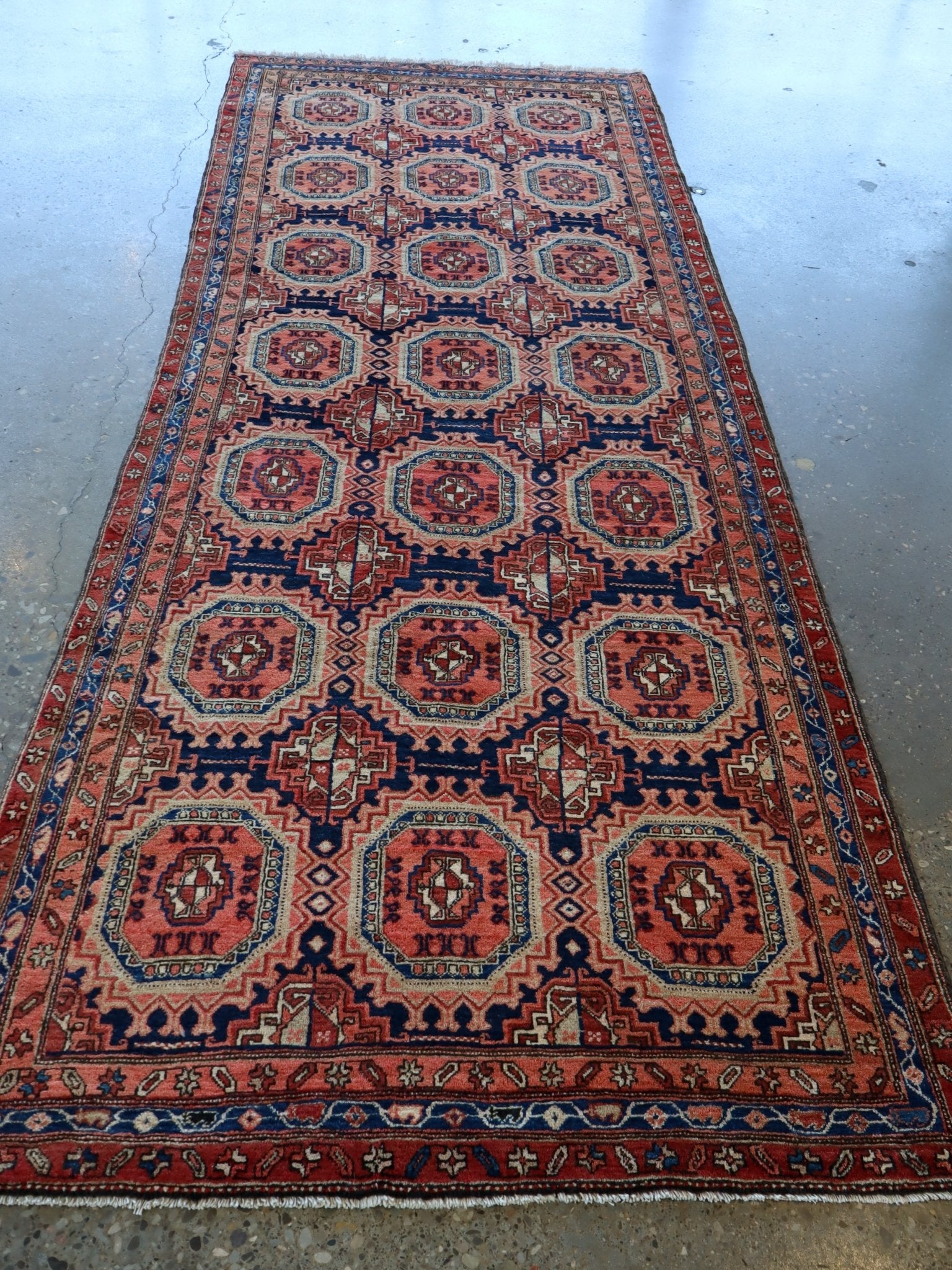 Persian-style runner rug with symmetrical red, blue, and cream octagon pattern