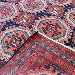 Persian runner rug close-up of rosette medallions and zigzag border in navy red