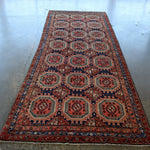 Persian-style runner rug full view with red border and navy geometric medallions