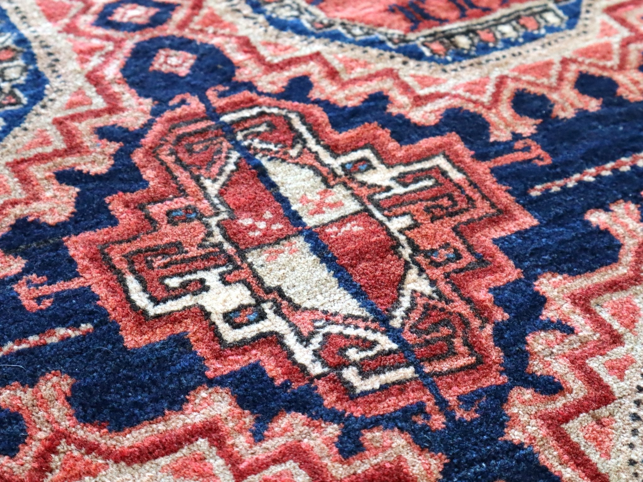 Persian runner rug close-up with navy, red, and cream geometric motifs