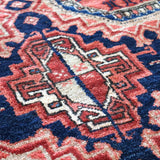 Persian runner rug close-up with navy, red, and cream geometric motifs