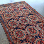 Persian runner rug with rust red, navy, and cream medallions in a grid