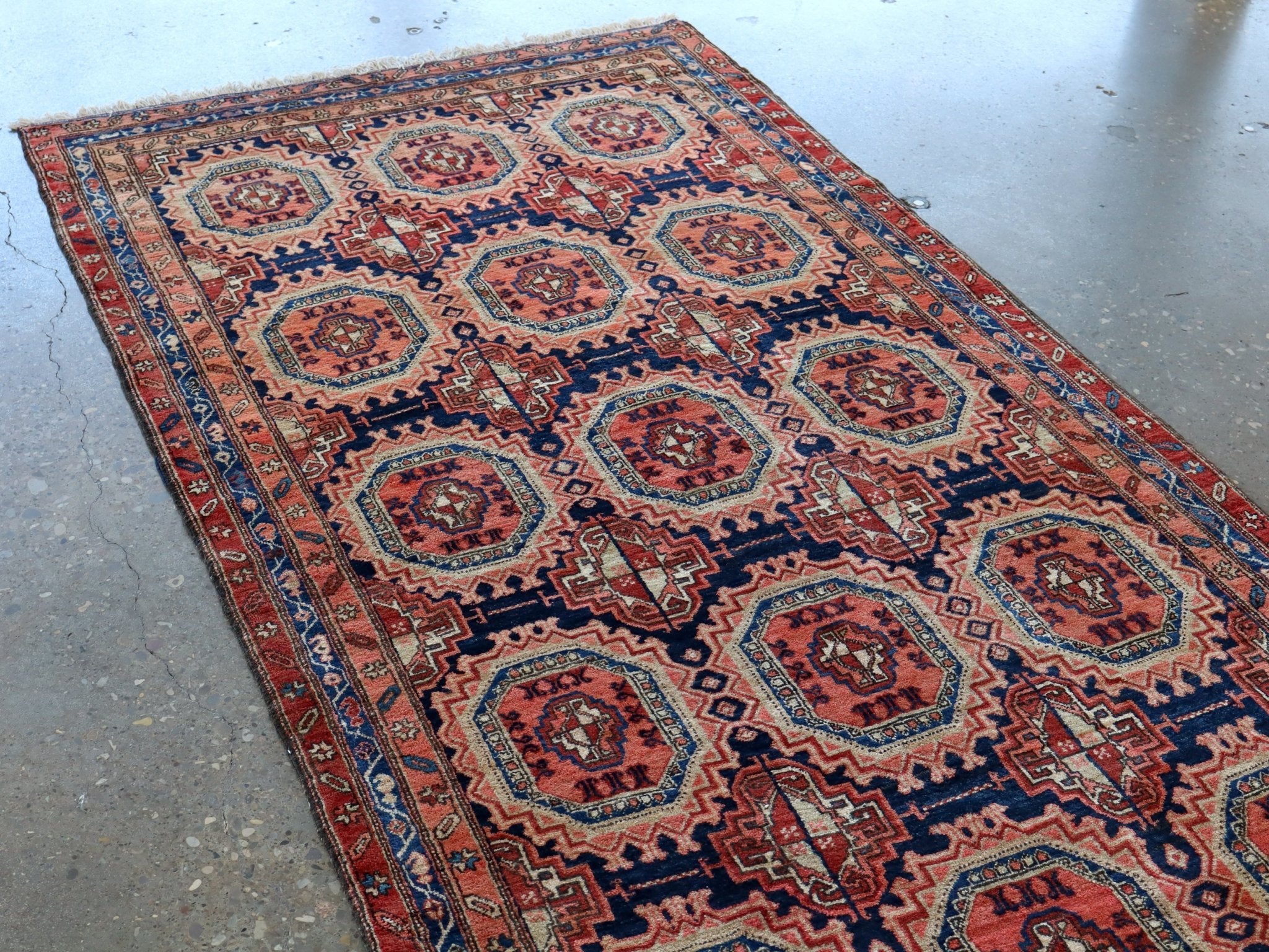 Persian runner rug with rust red, navy, and cream medallions in a grid