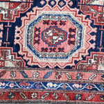 Persian-style runner rug border close-up with red, navy, and cream ornamental trim