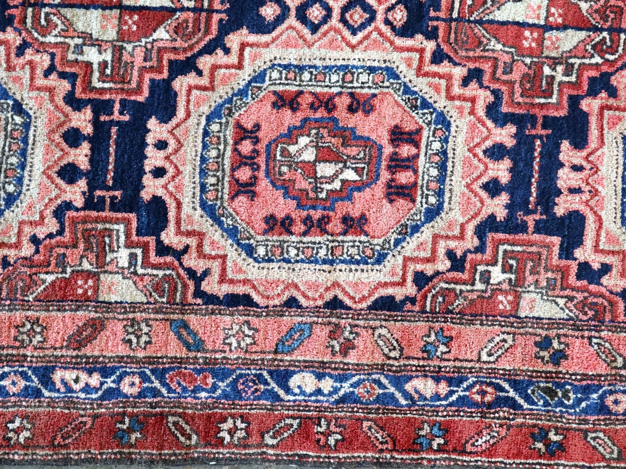 Persian-style runner rug border close-up with red, navy, and cream ornamental trim