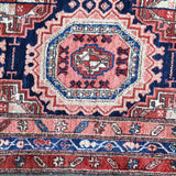 Persian-style runner rug border close-up with red, navy, and cream ornamental trim