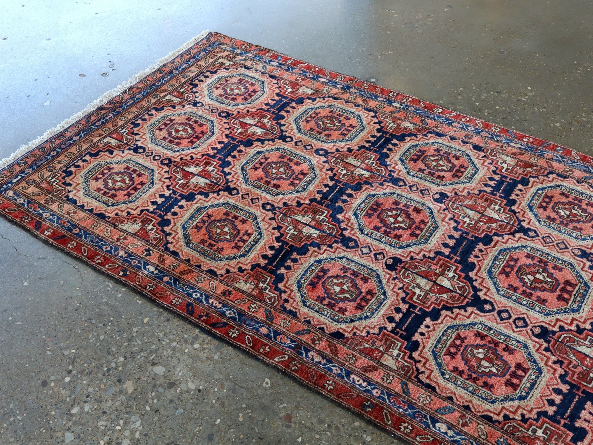 Persian runner rug with repeating octagon medallions in red, navy, and cream