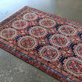 Persian runner rug with repeating octagon medallions in red, navy, and cream