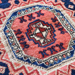 Persian-style runner rug center medallion close-up in red, blue, and cream