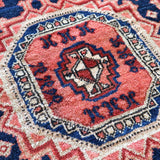 Persian-style runner rug center medallion close-up in red, blue, and cream