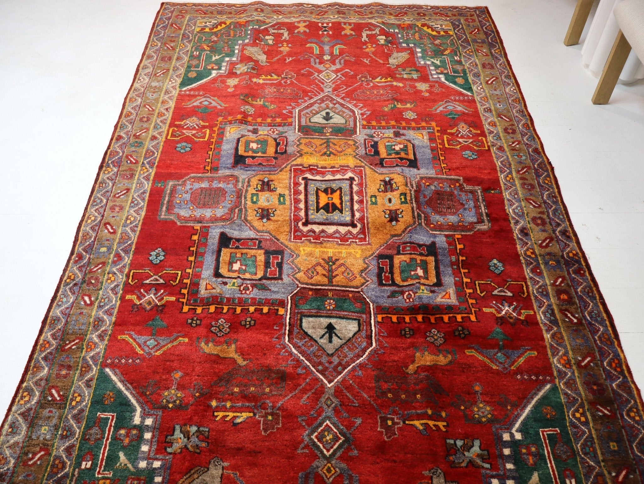 Red Persian-style rug with central octagon medallion and ornate border pattern.