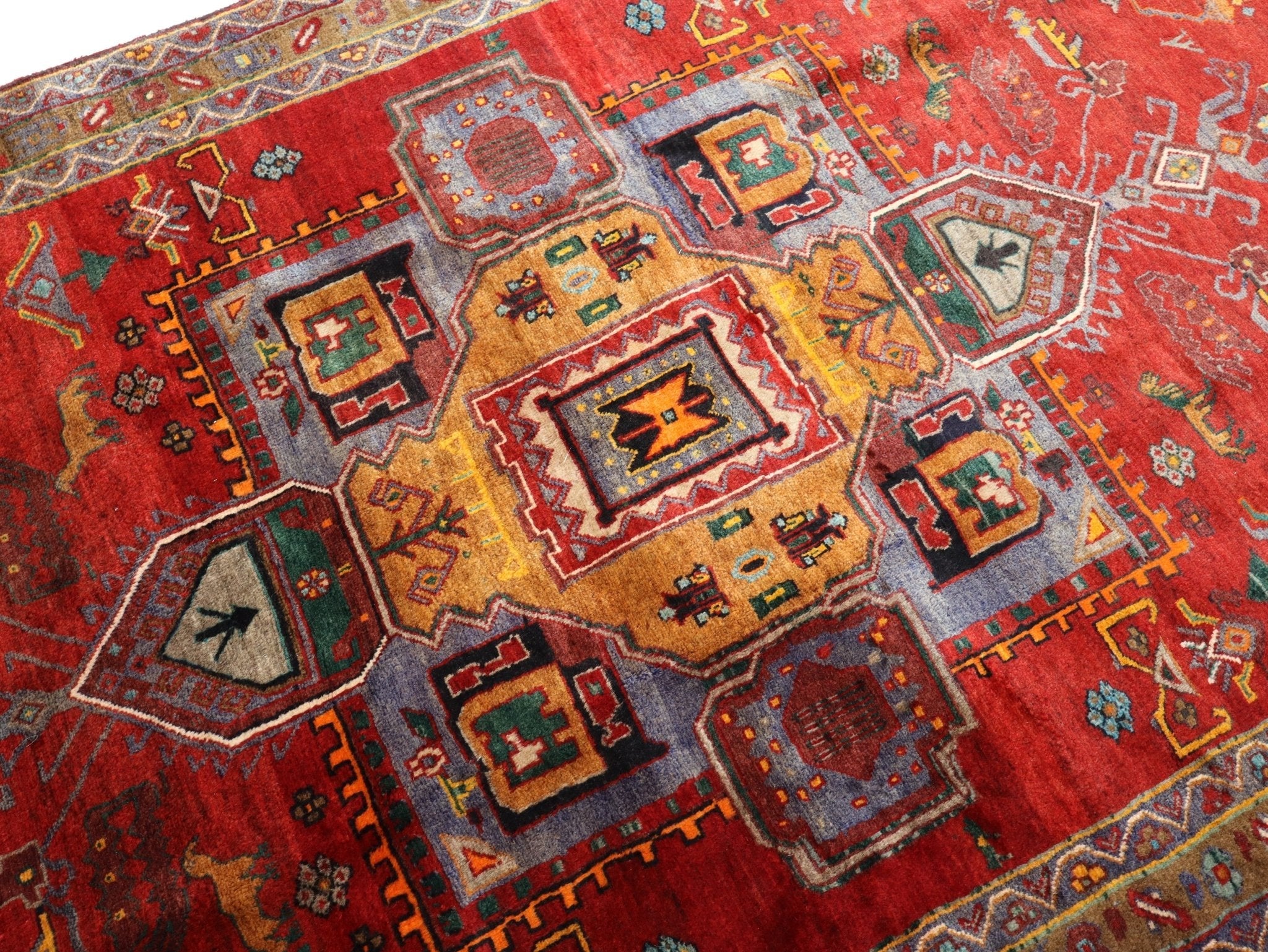 Red Persian-style area rug with multicolor geometric medallions and border.