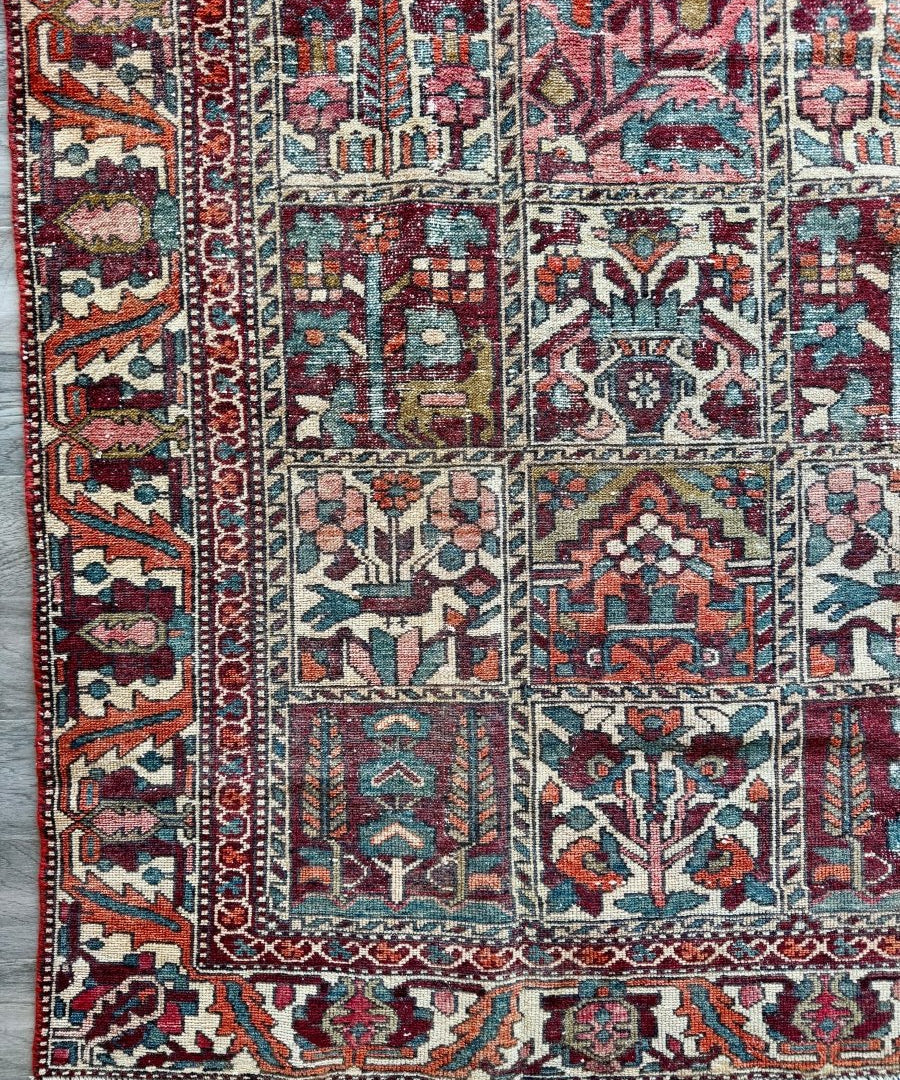 Perisan Bakhtiari rug with red and blue medallions and geometric borders, cream ground.