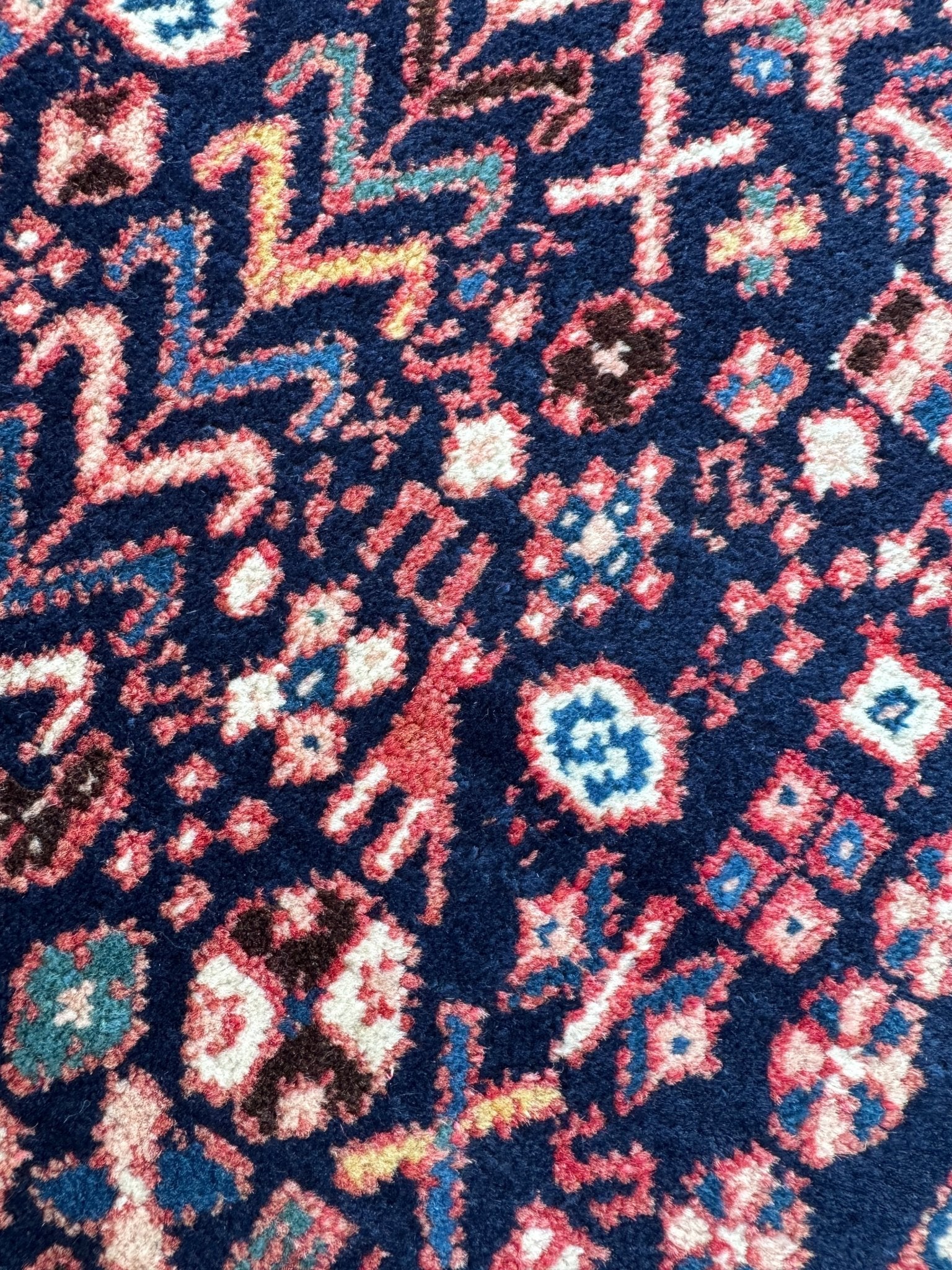 Geometric pattern rug with navy background and red, cream, turquoise accents