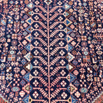Persian-style area rug in navy blue with diamond and cross geometric motifs.