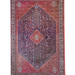 Full view Persian-style rug with red border, navy center, and diamond medallion