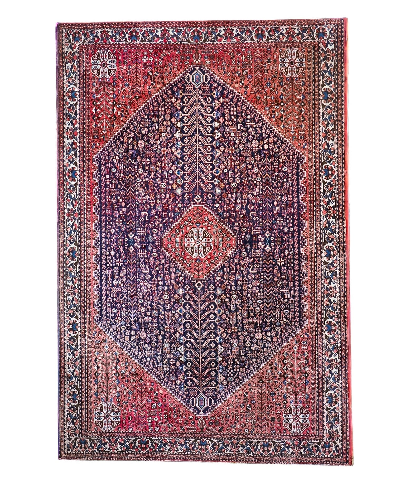 Full view Persian-style rug with red border, navy center, and diamond medallion