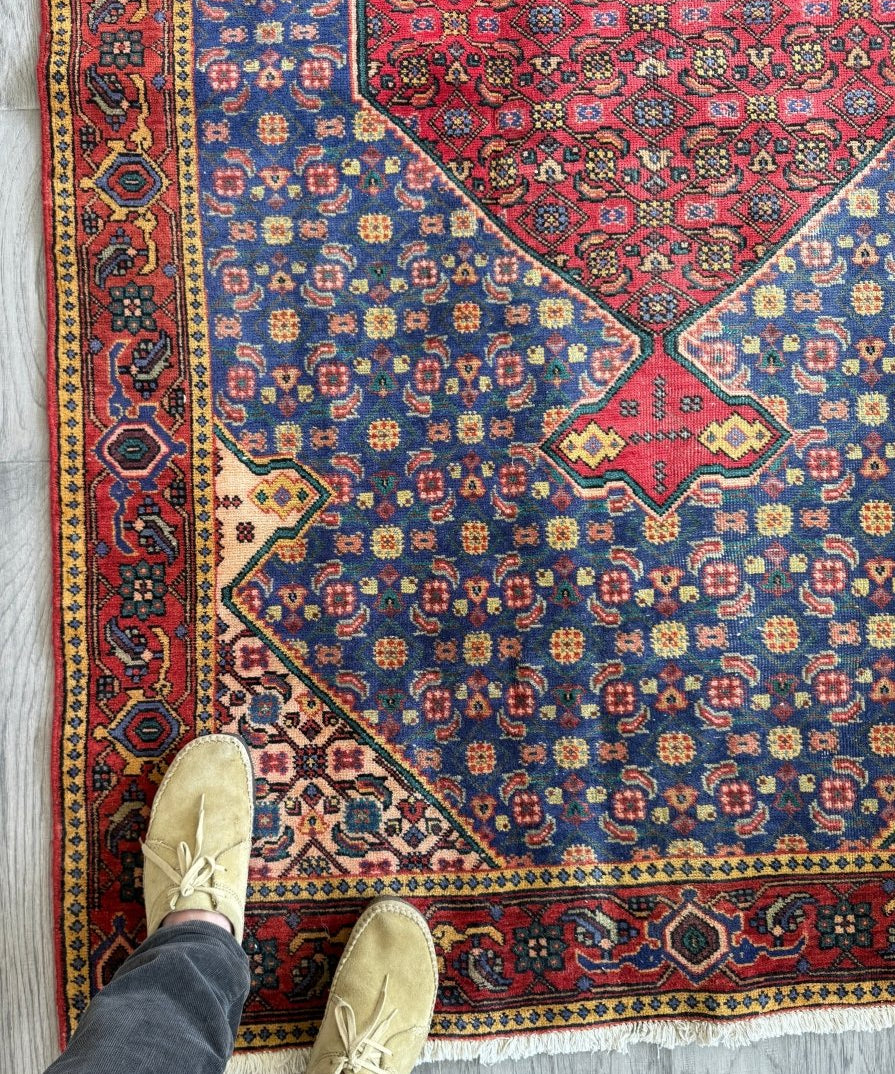 Persian-style area rug with blue field, red medallion and multicolor floral motifs