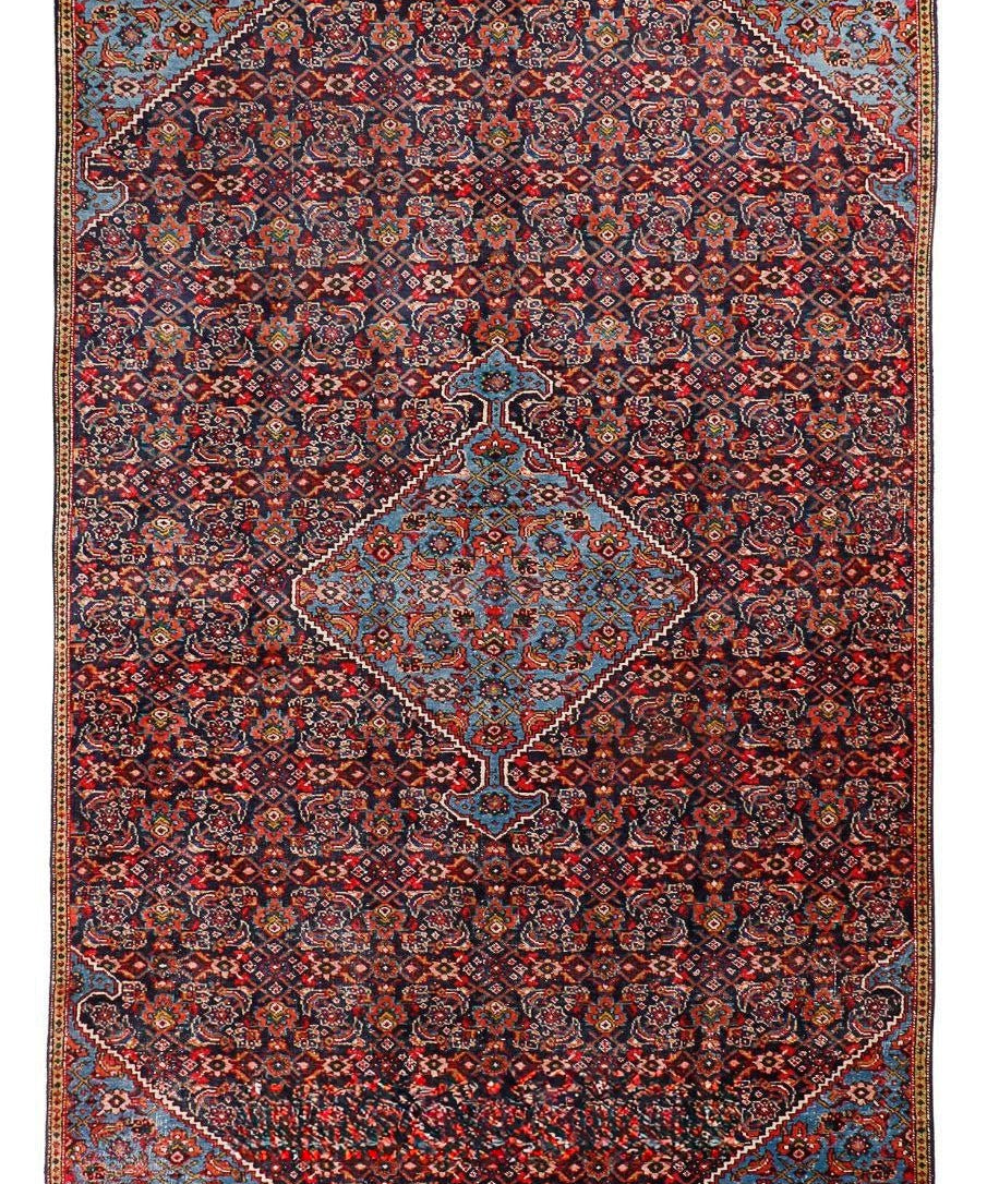 Persian-style area rug with red ground, blue accents, diamond medallion and border