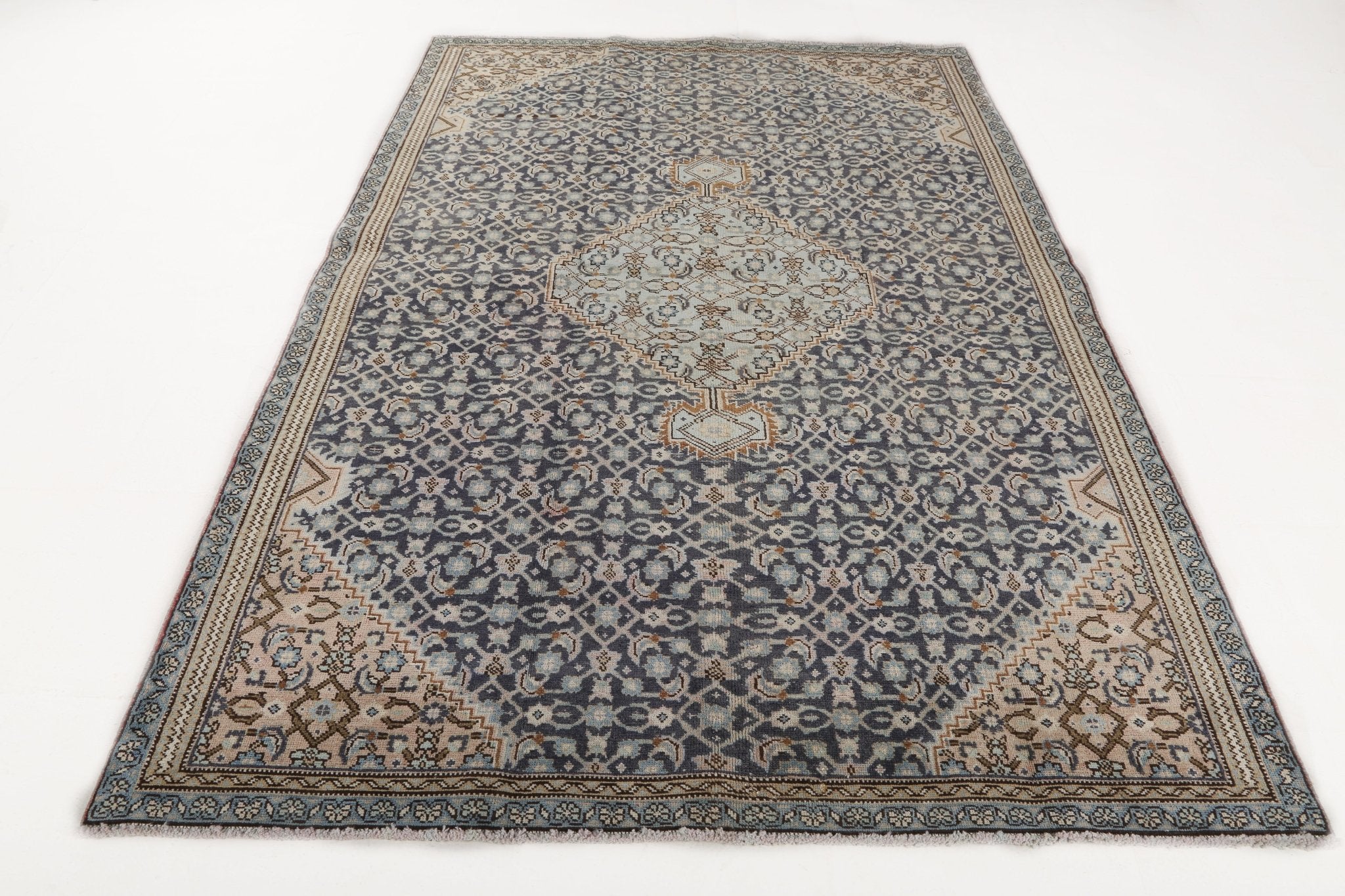 Woven rug with navy-blue center medallion and tan border accents