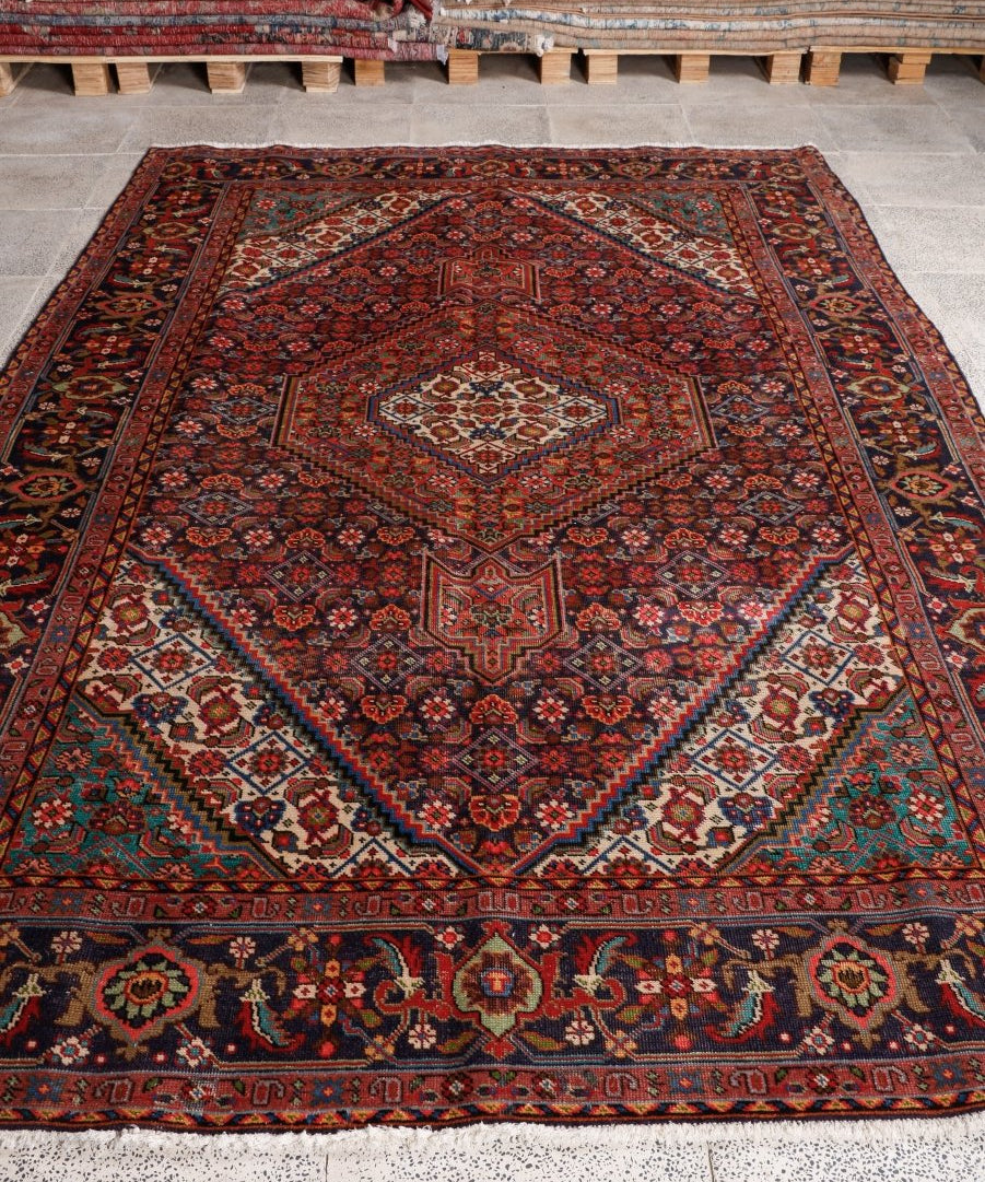 Persian Ardabil-style rug with dark red field, teal accents, and central diamond medallion