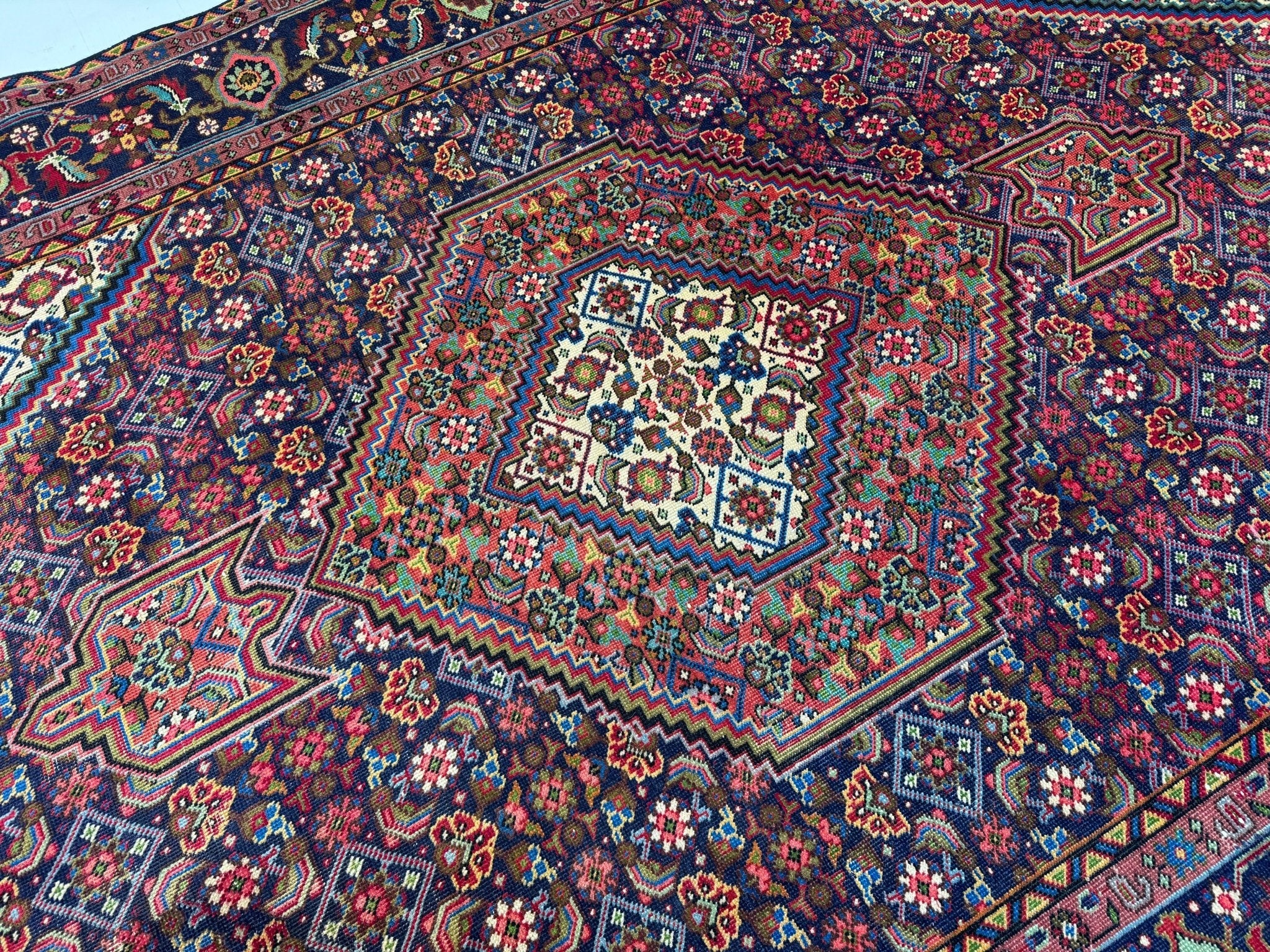 Persian Ardabil rug wide view with blue background and ornate red floral medallion patterns