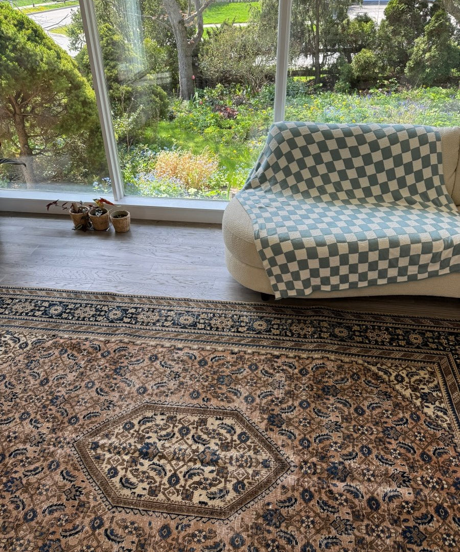 Persian-style rug laid flat with navy and cream floral geometric pattern and center medallion