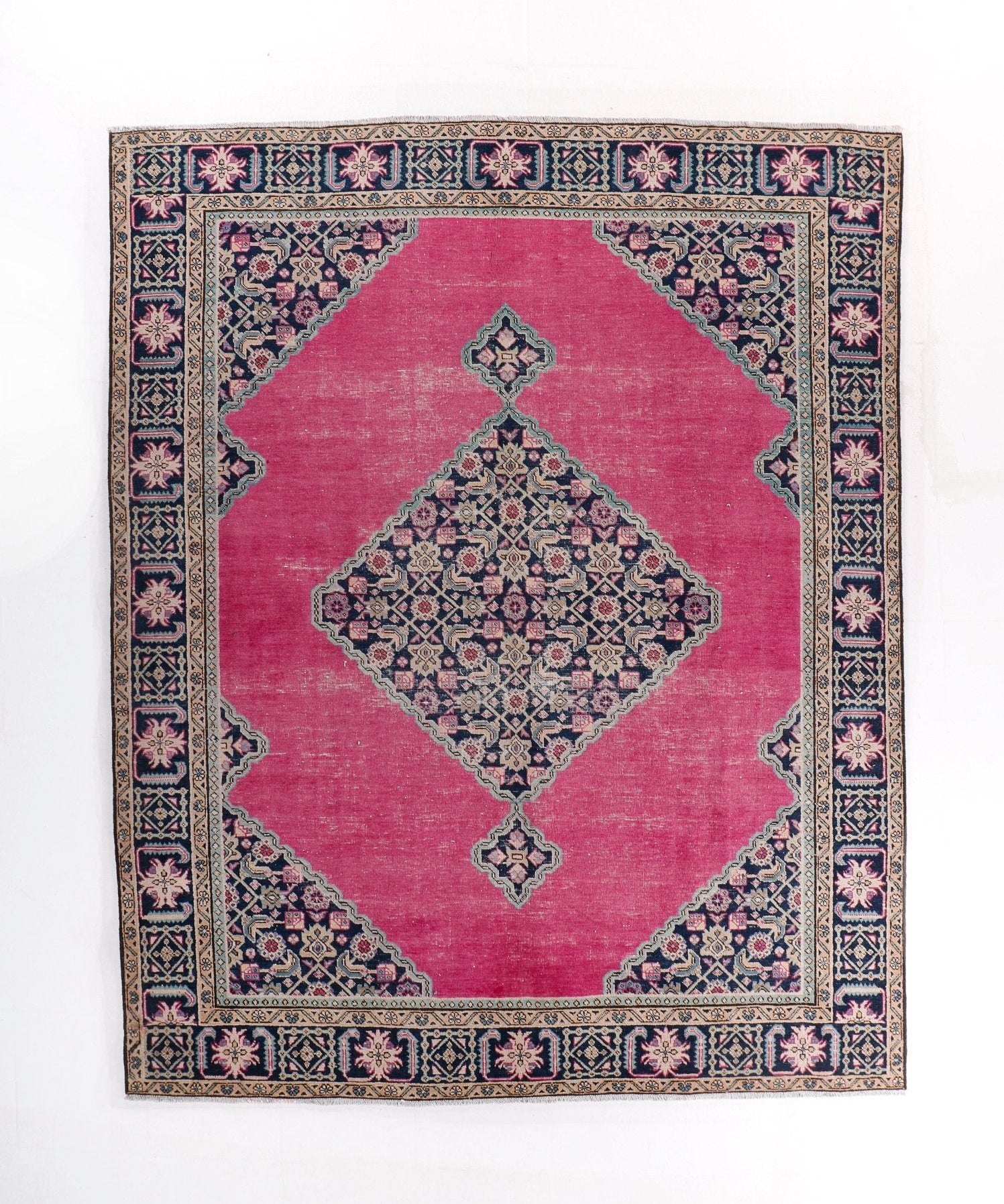 Persian Ardabil rug with pink field, navy border, and central geometric medallion