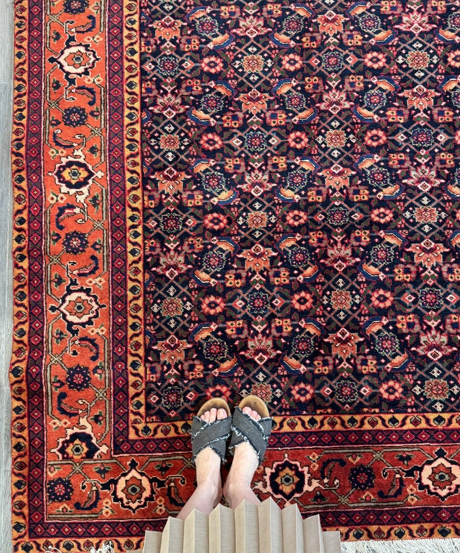 Persian Ardabil rug with navy and rust geometric medallion design, cream fringe edge