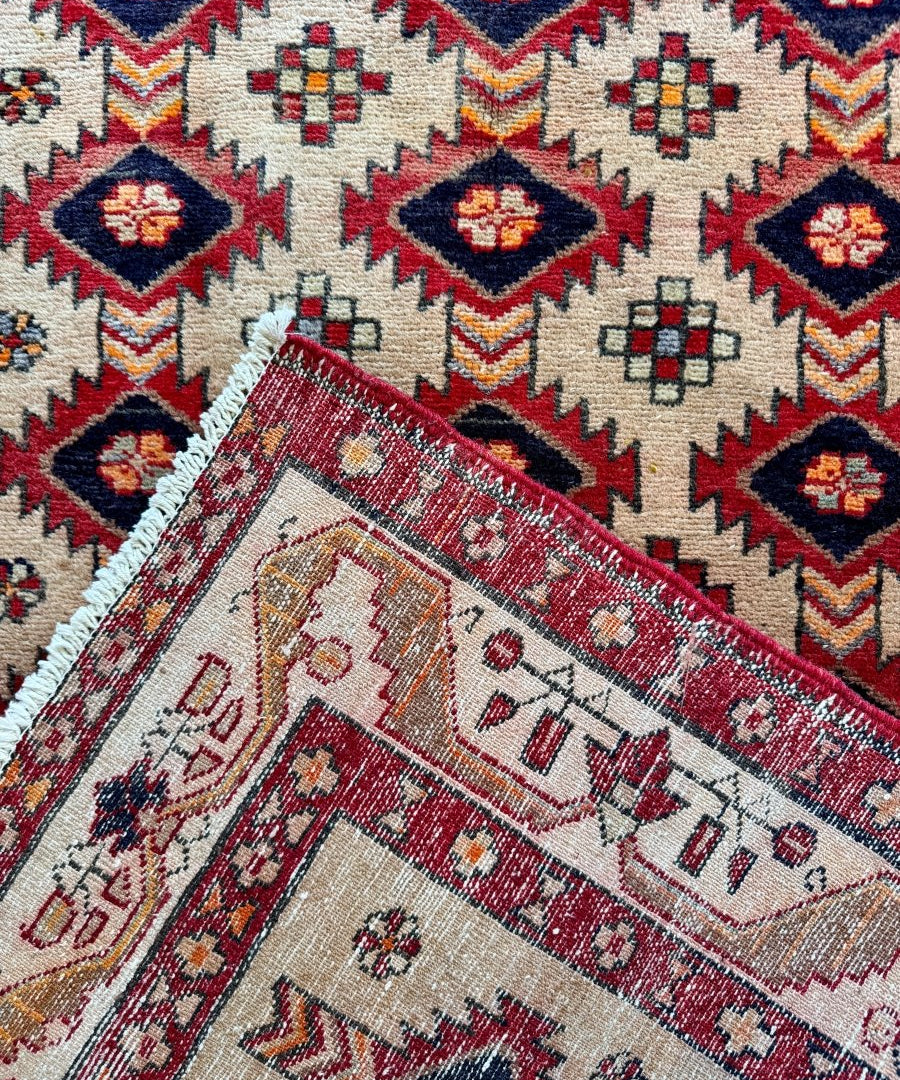 Persian Azerbaijan runner rug corner with red band, cream ground, and multicolor geometric details