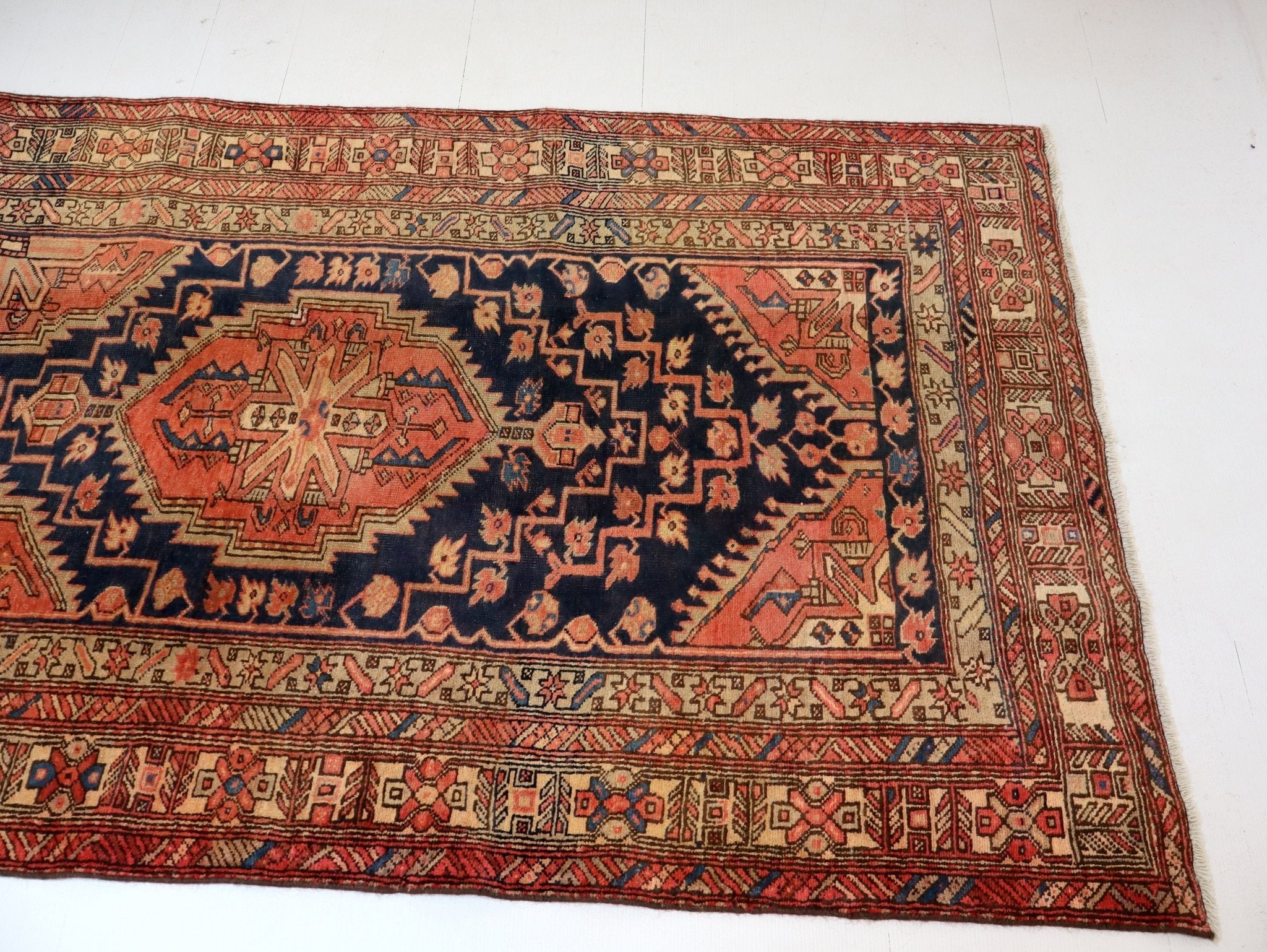 Persian Azerbaijani runner rug corner showing geometric border and central tan medallion