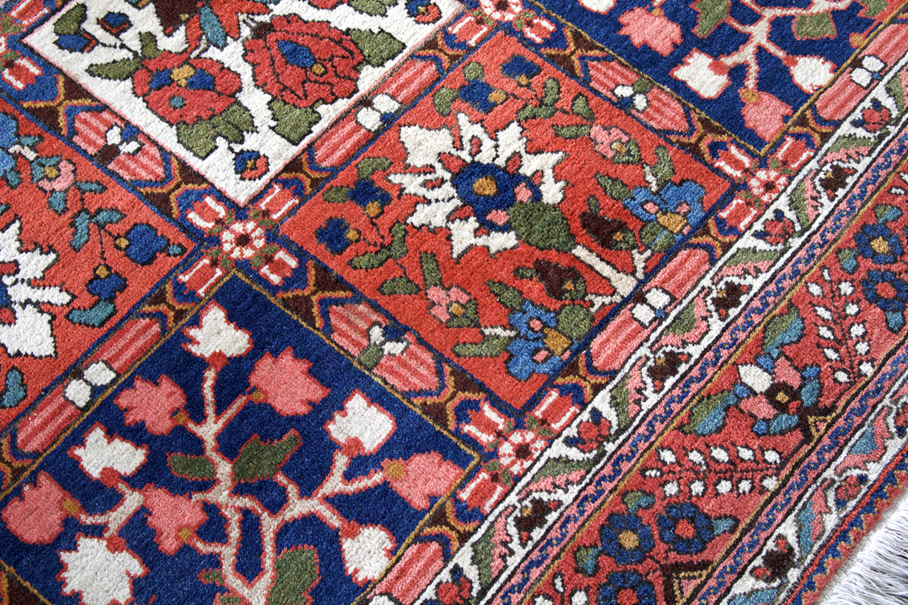 Persian Bakhtiari rug diagonal close-up with red, blue, green, and ivory floral patterns