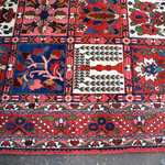 Persian Bakhtiari rug with red, blue, and white floral geometric border details
