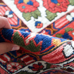 Persian Bakhtiari rug corner with multicolor geometric motifs and hand-knotted fringe
