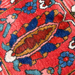 Persian Bakhtiari rug close-up with red ground, blue accents, and ivory diamond details
