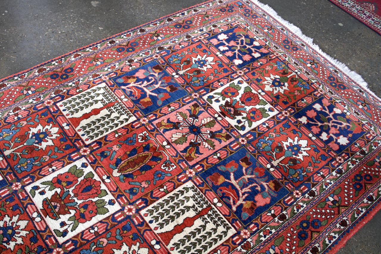 Persian Bakhtiari rug top view with red grid panels, floral motifs, and short fringes