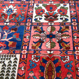 Persian Bakhtiari rug close-up of floral and star motifs in red, blue, and green