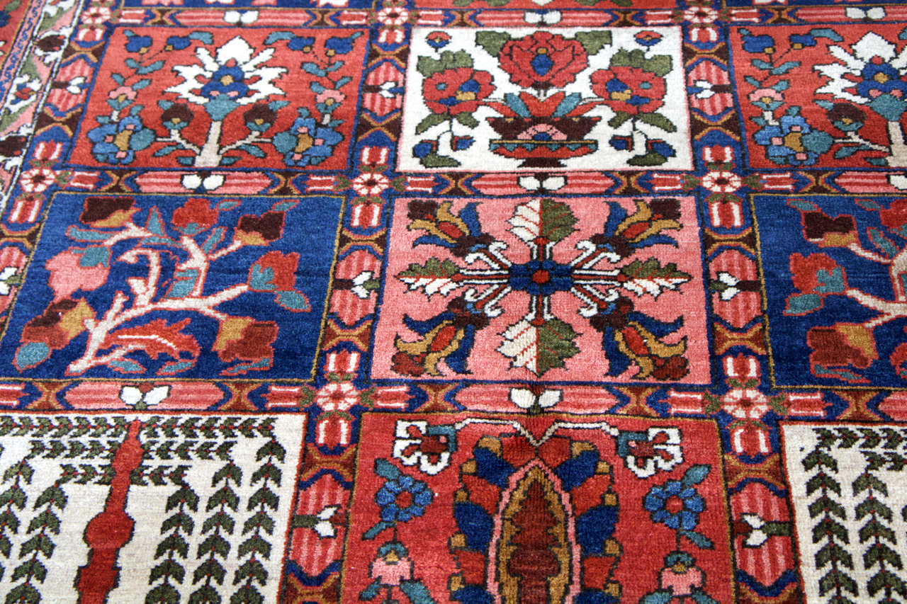 Persian Bakhtiari rug close-up of floral and star motifs in red, blue, and green