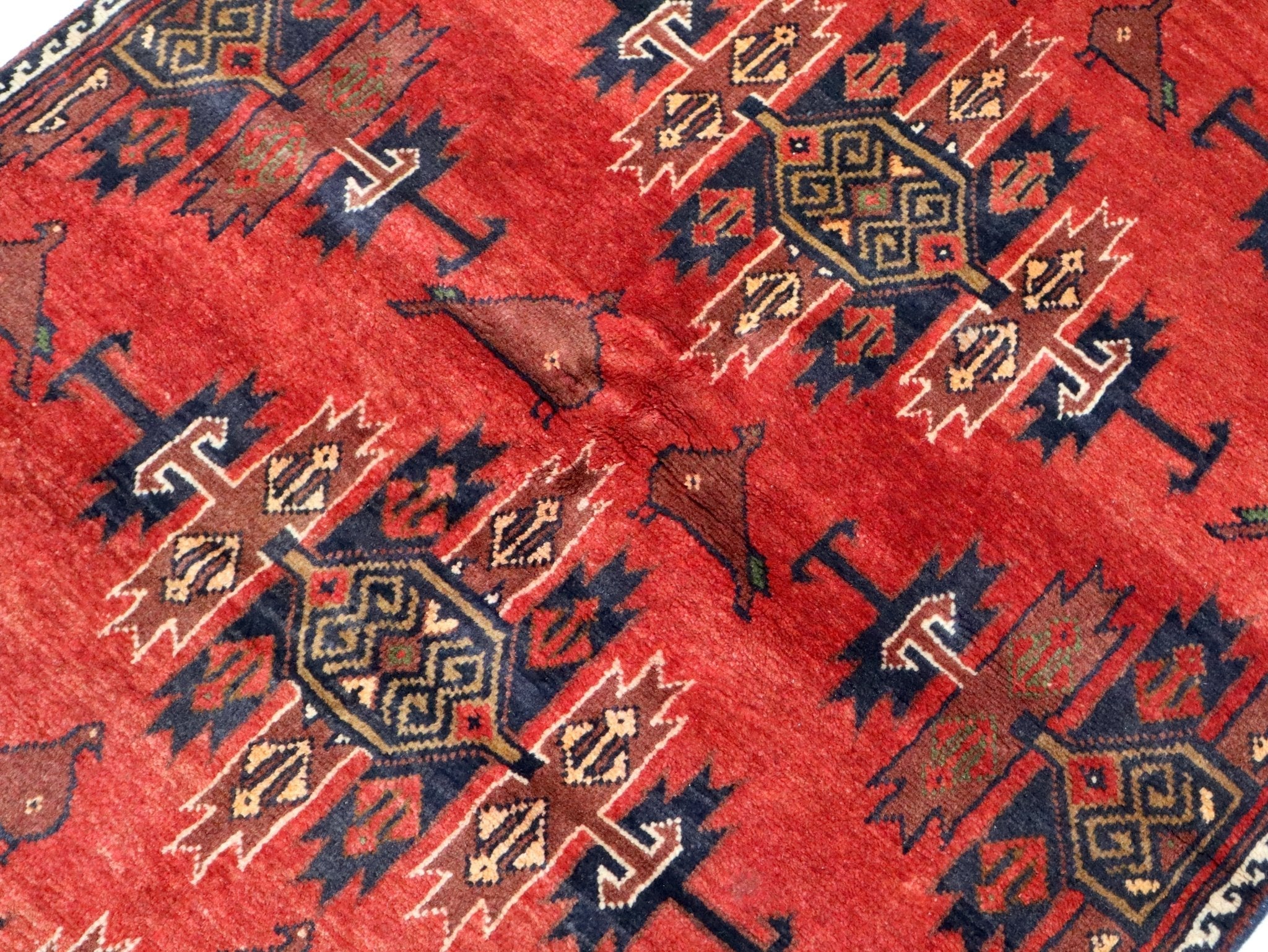 Persian Baluch rug: red field with blue geometric medallions, 3'3" x 5'9"