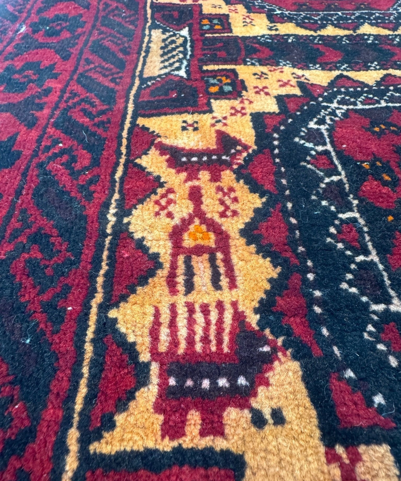 Worn Persian-style runner rug with navy, burgundy, and gold geometric medallion patterns