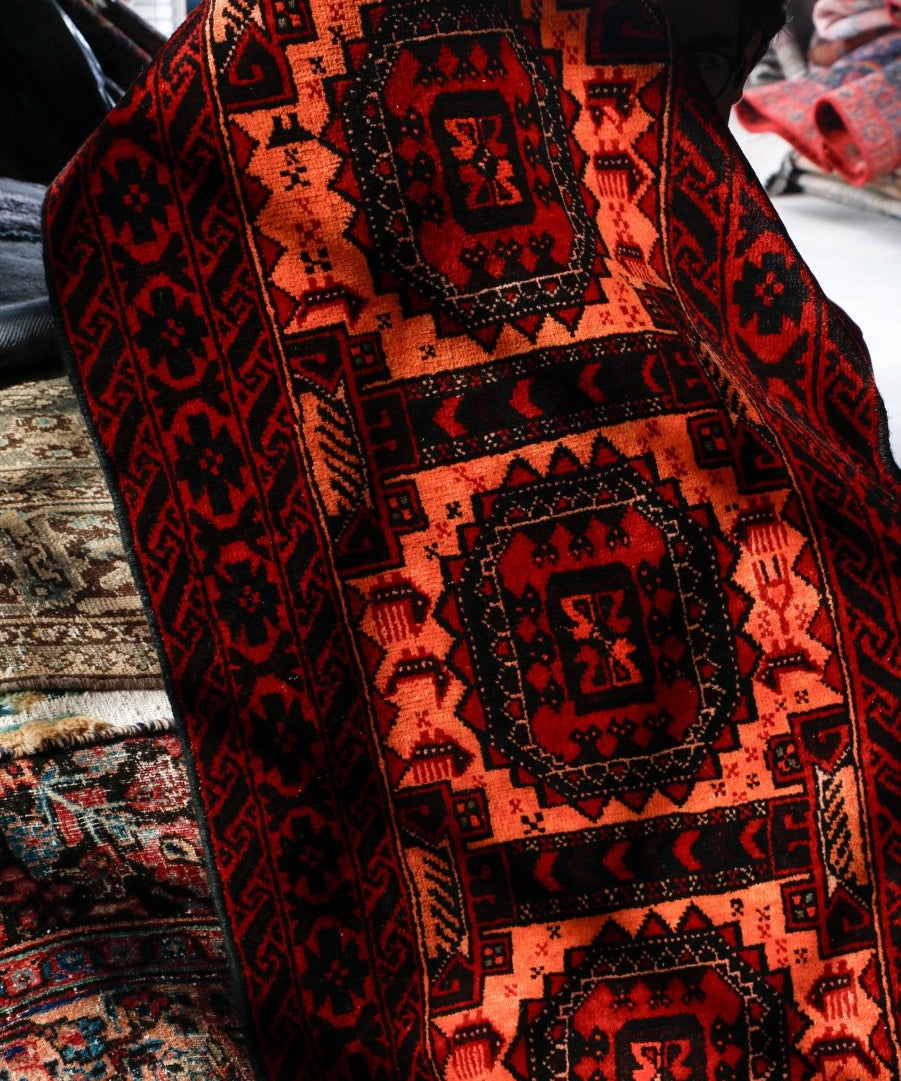 Persian Baluch runner rug stacked view with red, orange, and navy repeating medallions