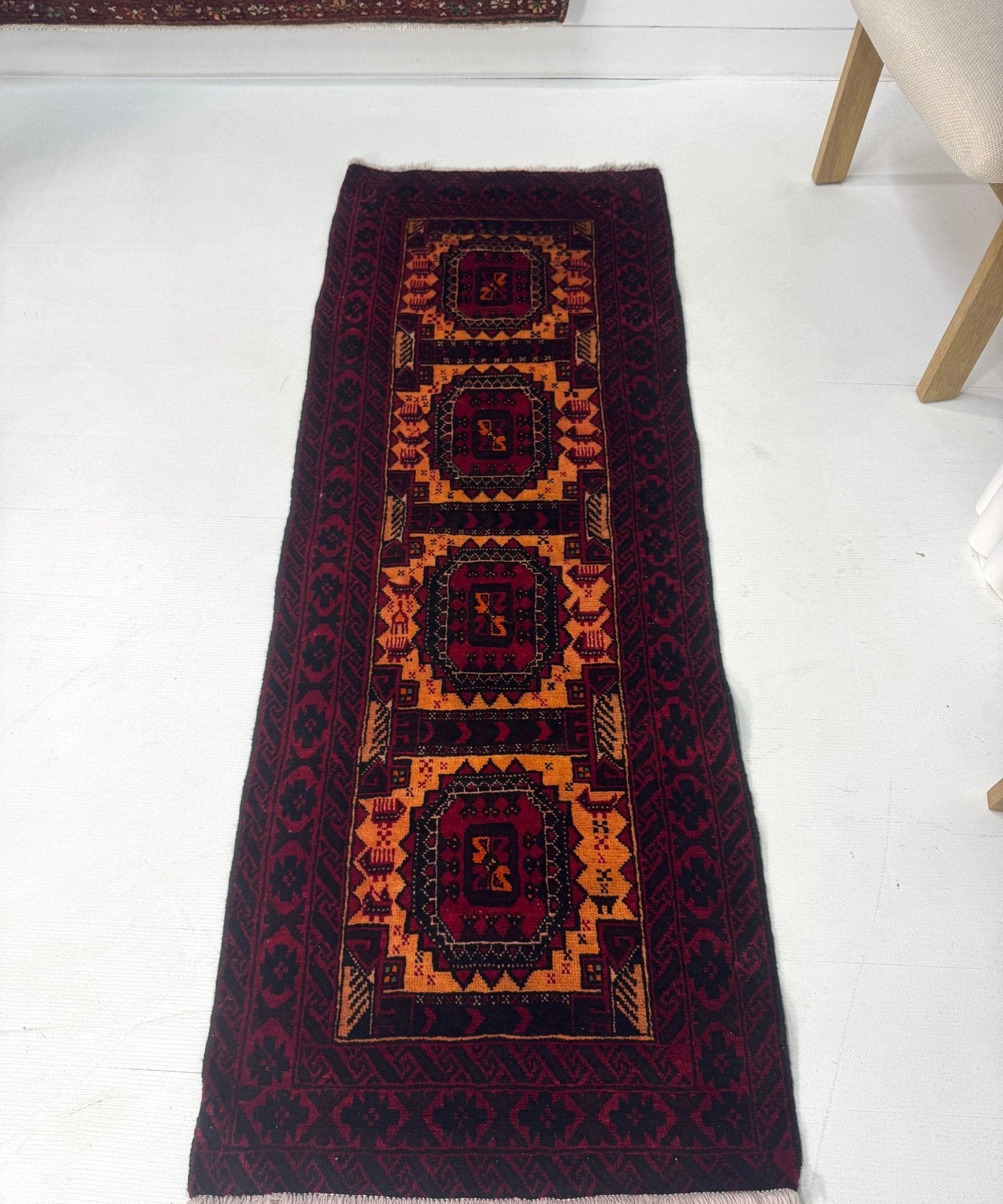 Persian-style runner rug, deep burgundy with navy and gold medallion motifs, short pile