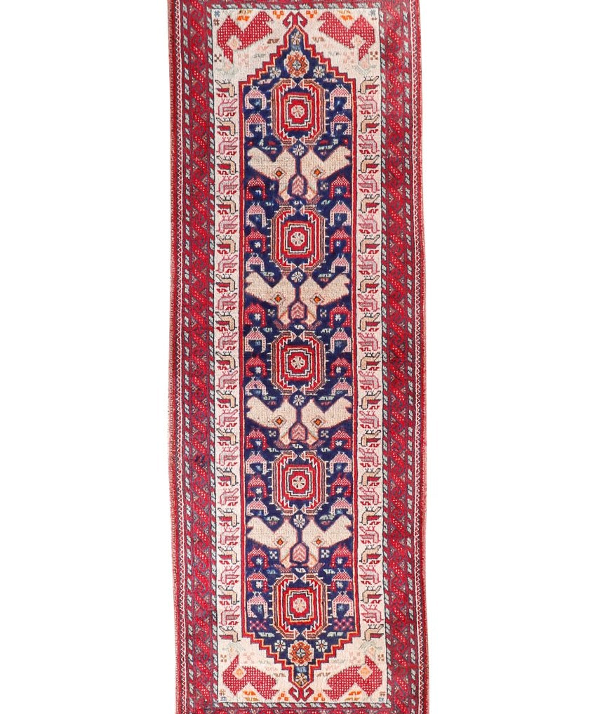 Persian Baluch runner rug with red, navy, and cream geometric medallion border